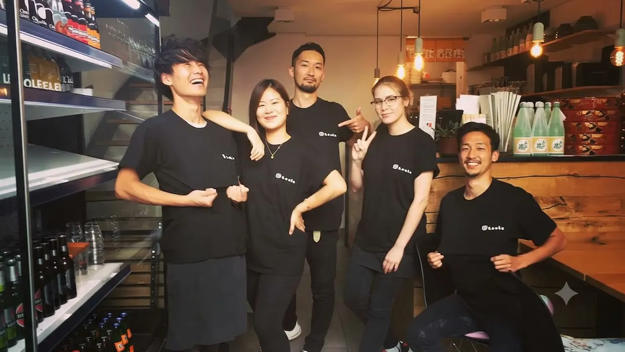 Fünf Mitarbeitende der Bento Boutique in schwarzen T-Shirts mit Bento-Logo, nebeneinander im Laden zwischen Kühlregal und Sushi-Theke